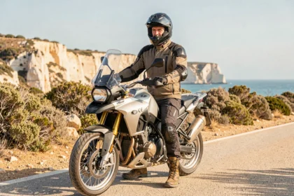 Motard équipé de matériel de sécurité homologué sur une route côtière ensoleillée près d'Agde